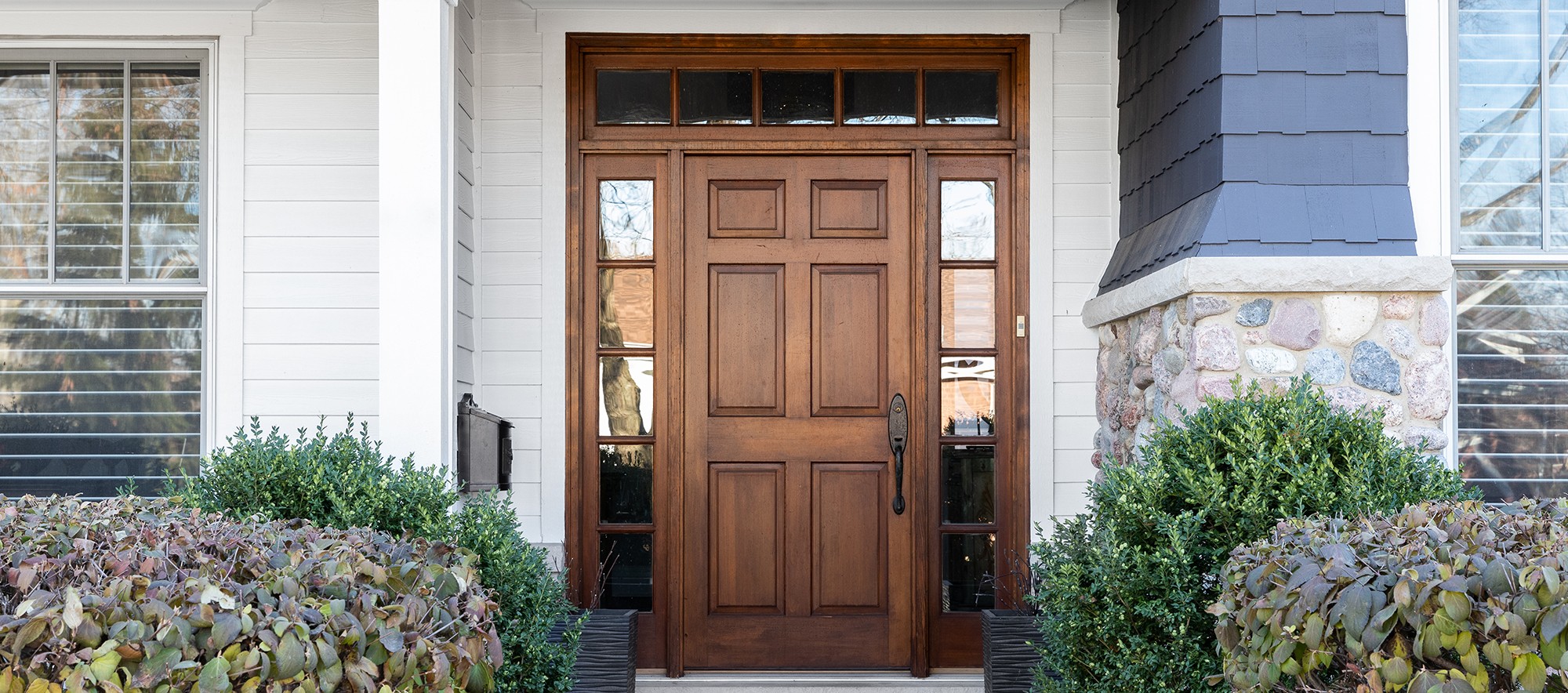 Brown stained front door with sidelights and transom windows