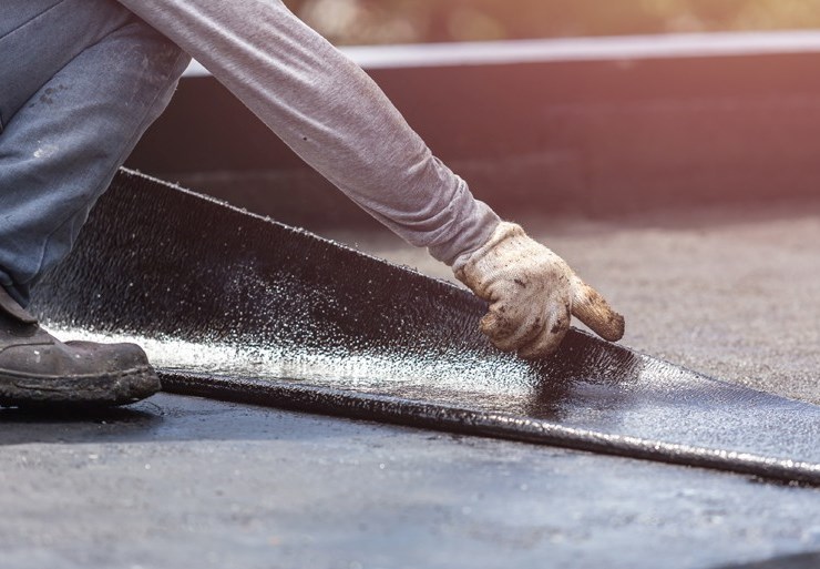 Commercial roofing contractor repairing flat roof